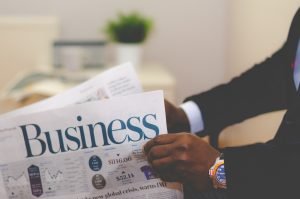 Man holding the business section of the newspaper