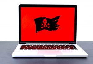 Laptop with a black pirate flag on a red background