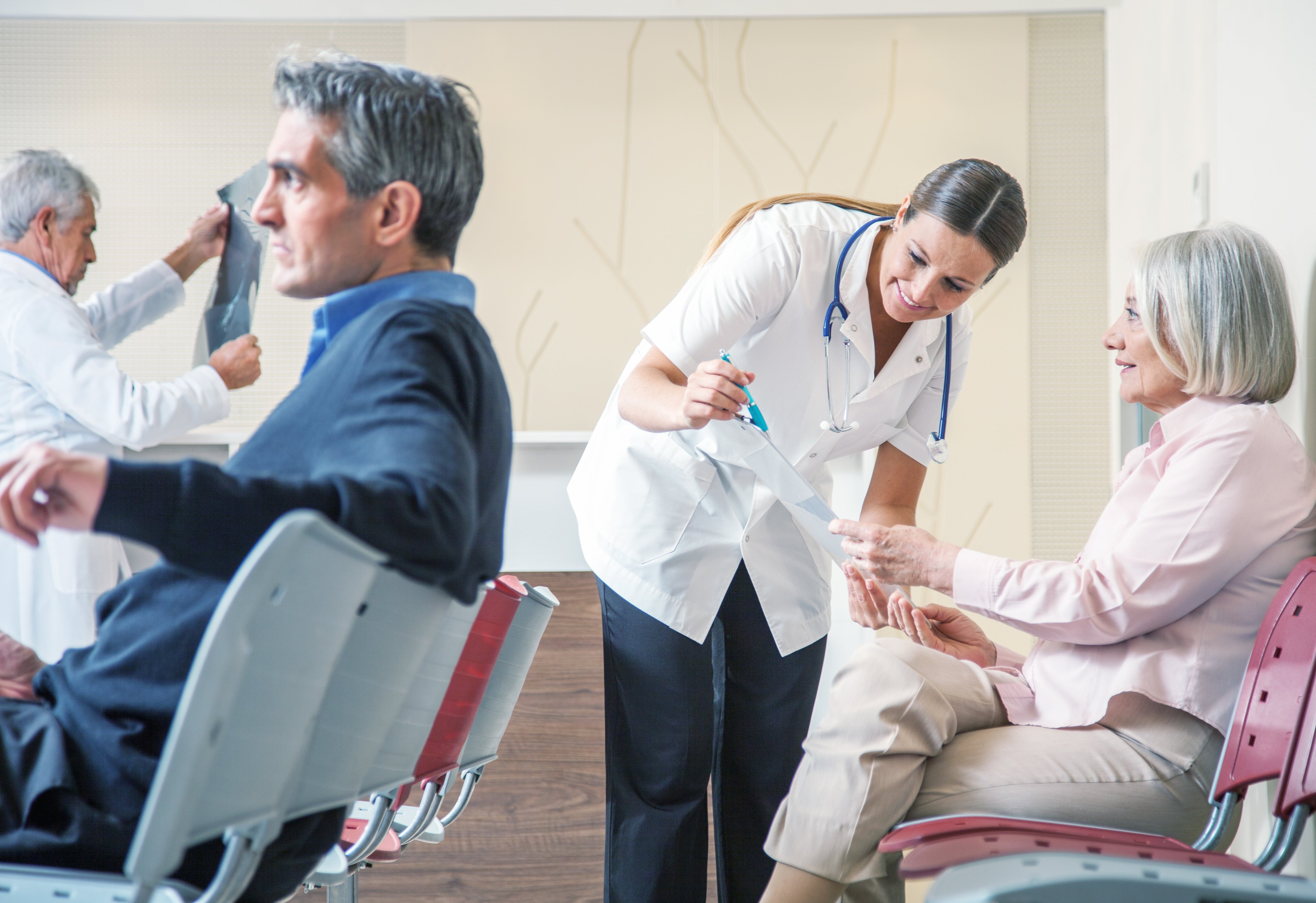 Doctors and patients speaking in the hospital waiting room