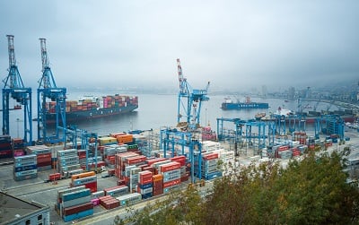 Shipping yard with cargo ships leaving the port on a cloudy day